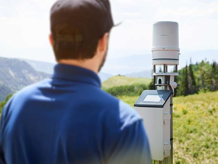 Researcher standing in front of a ZL6 data logger and ATMOS 41 weather station