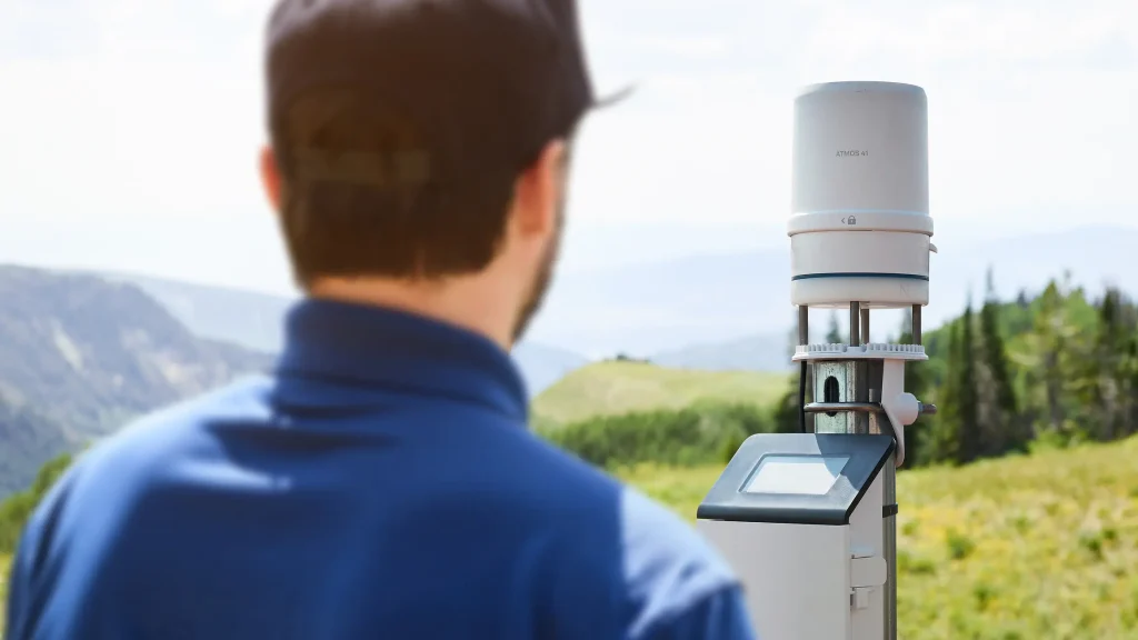 Researcher standing in front of a ZL6 data logger and ATMOS 41 weather station