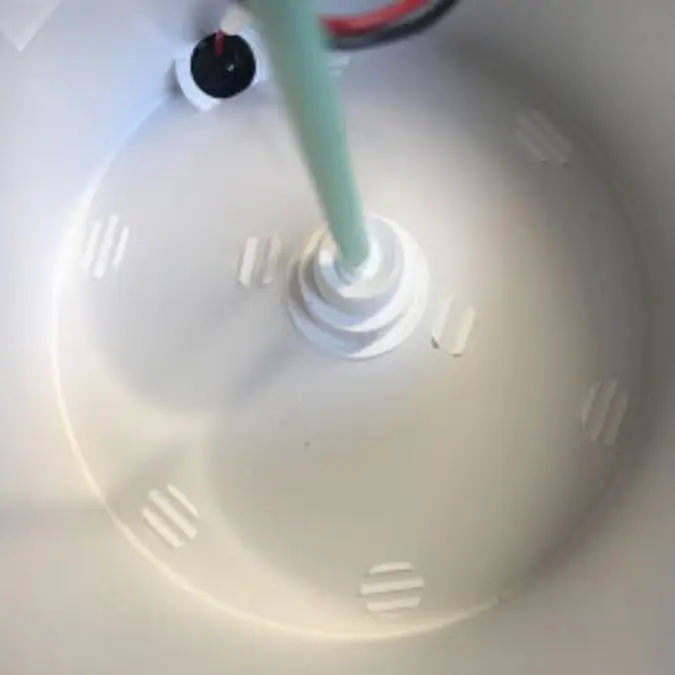 A photograph of someone using a cleaning swab to clean the inside of the nozzle