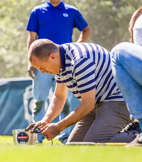 Researchers installing TEROS 21 water potential sensors under the turfgrass at BYU