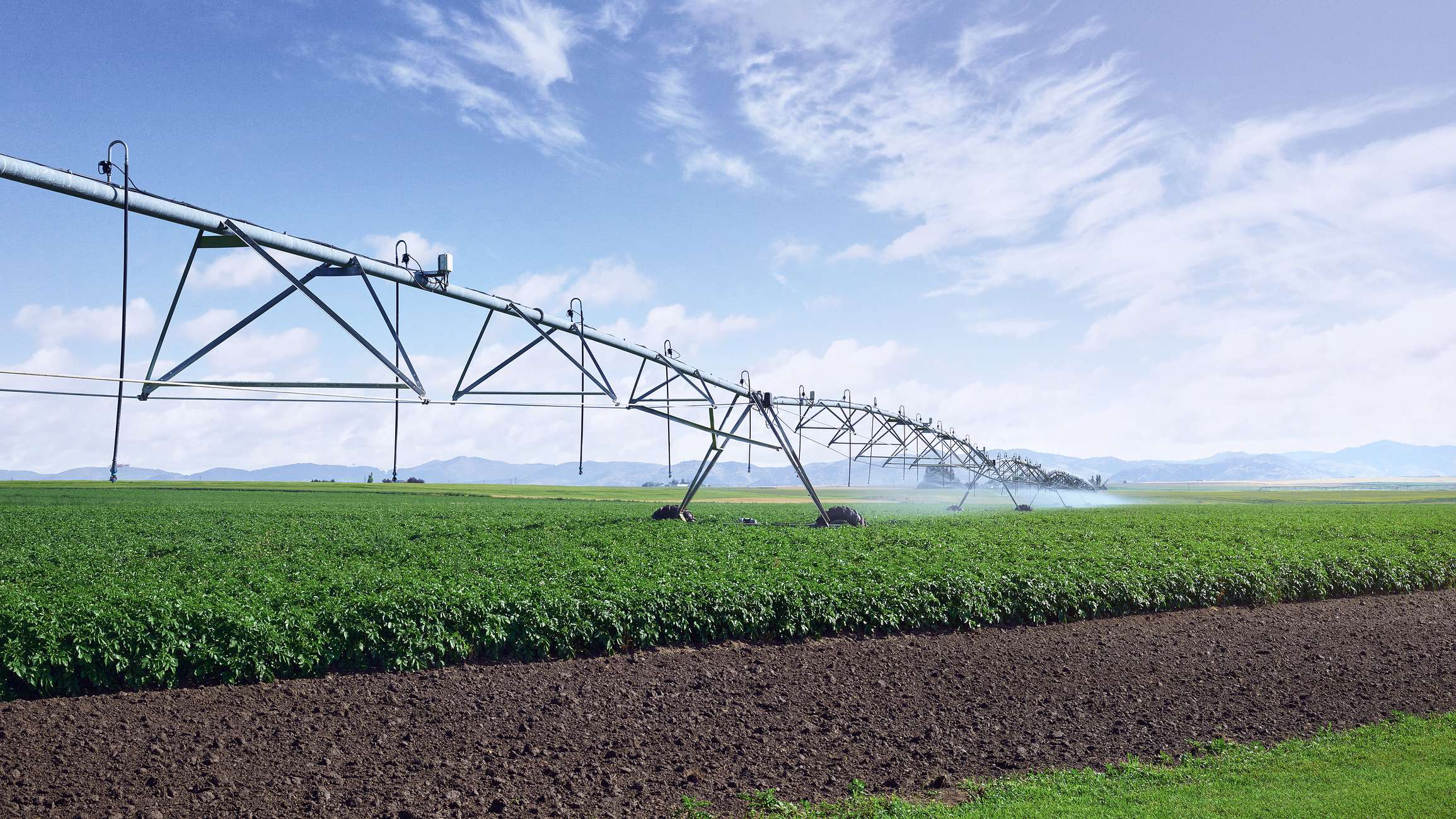 A photograph of a pivot irrigation system watering a field of crops