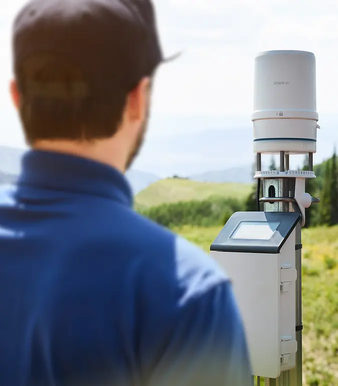 Researcher studying climate change adjusts ATMOS 41 weather station
