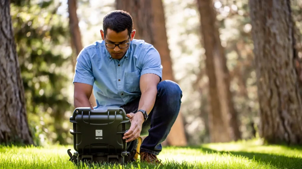Picture of a researcher with the SATURO infiltrometer which measures field saturated hydraulic conductivity