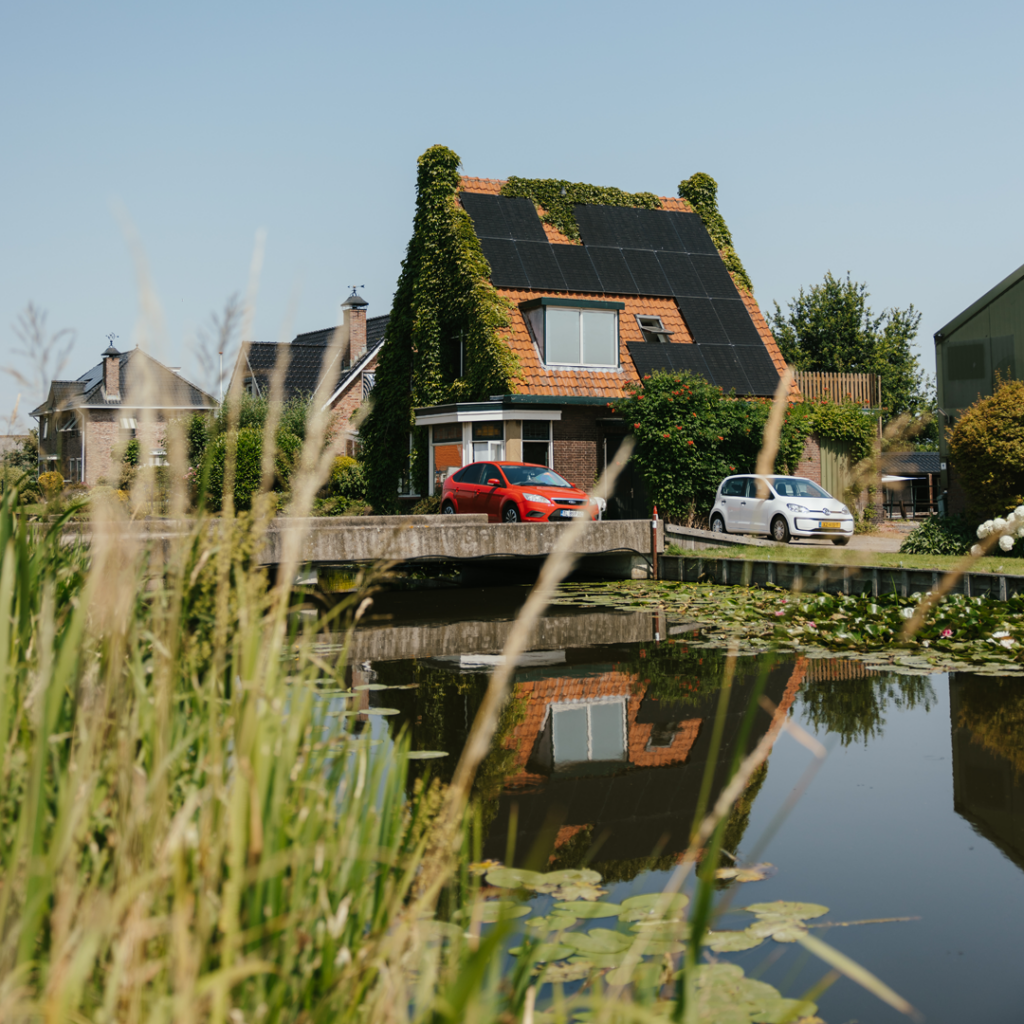 House with solar panels by water
